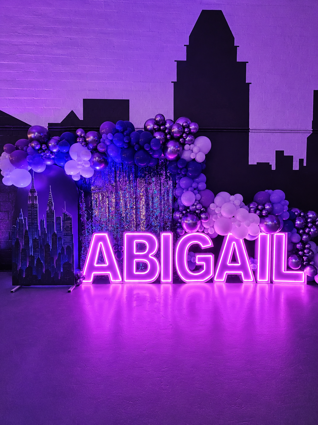 Pink LED marquee letters ABIGAIL with Baltimore skyline