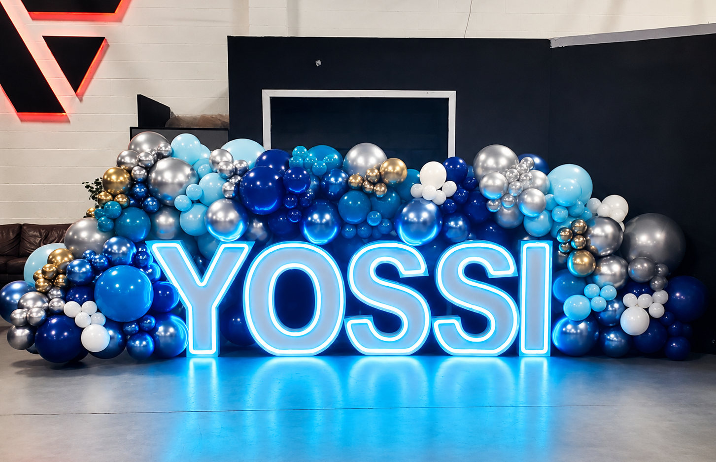 Blue LED marquee letters spelling YOSSI