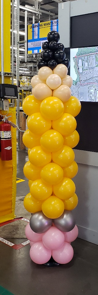 Yellow pencil-themed balloon column at an Amazon back-to-school event